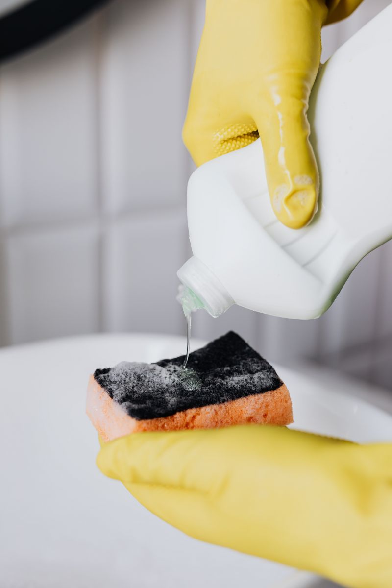 A glove, a sponge and cleaning supplies